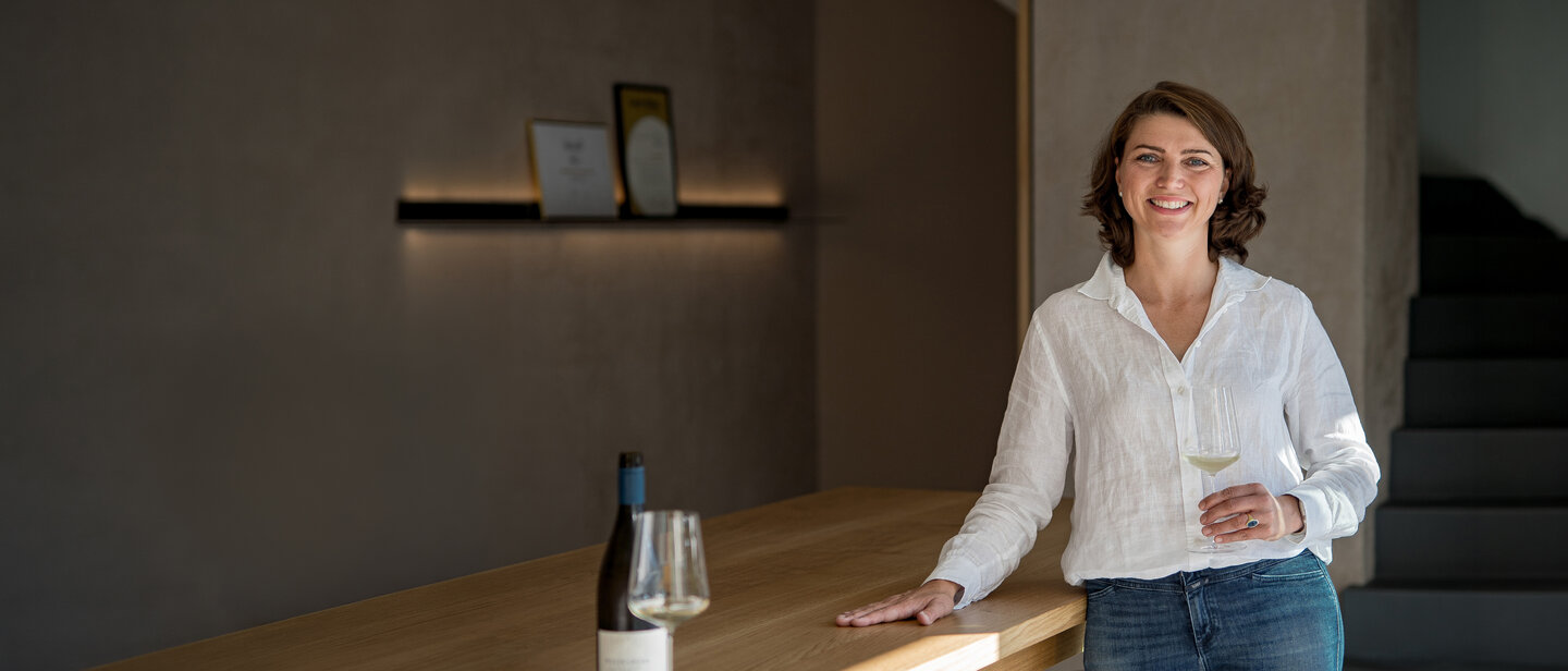 Gesine Roll mit einem Glas Sauvignon Blanc in der modernen Vinothek im alten Gutshof des Weinguts Weedenborn in Rheinhessen
